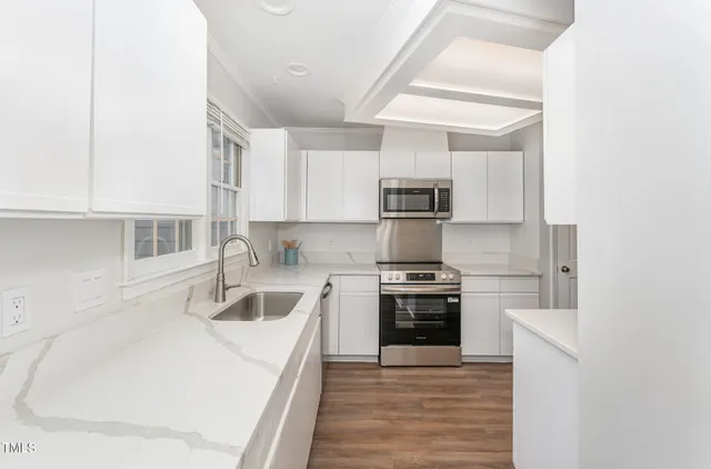 a kitchen with white cabinets and stainless steel appliances