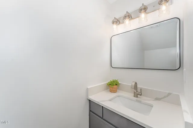 a bathroom with a sink vanity and a mirror