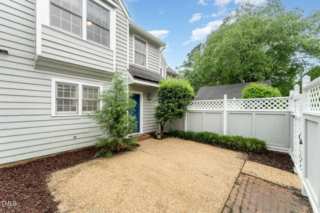 a view of a house with a yard and potted plants