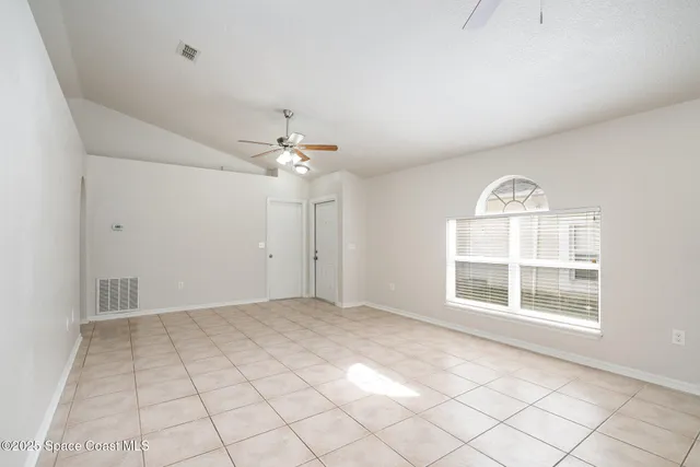 an empty room with windows and chandelier