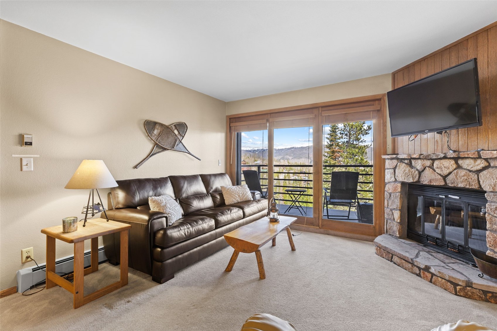 89410 Ryan Gulch Road, Unit DD301 Silverthorne, CO 80498 - Photo 8 of 28 a living room with furniture a fireplace and a flat screen tv