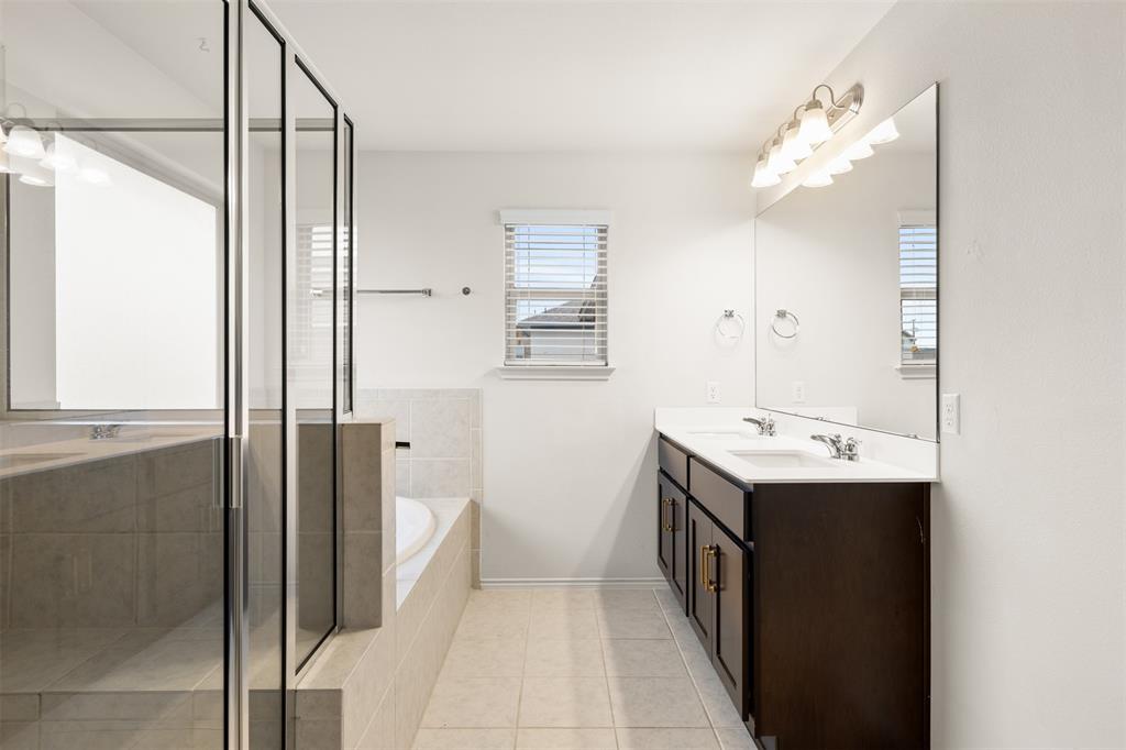 3560 Pauling Loop Round Rock, TX 78665 - Photo 4 of 28 Bathroom featuring double vanity, a garden tub, light tile patterned flooring, and a stall shower