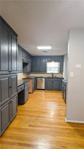a large kitchen with stainless steel appliances granite countertop a large counter top and a stove