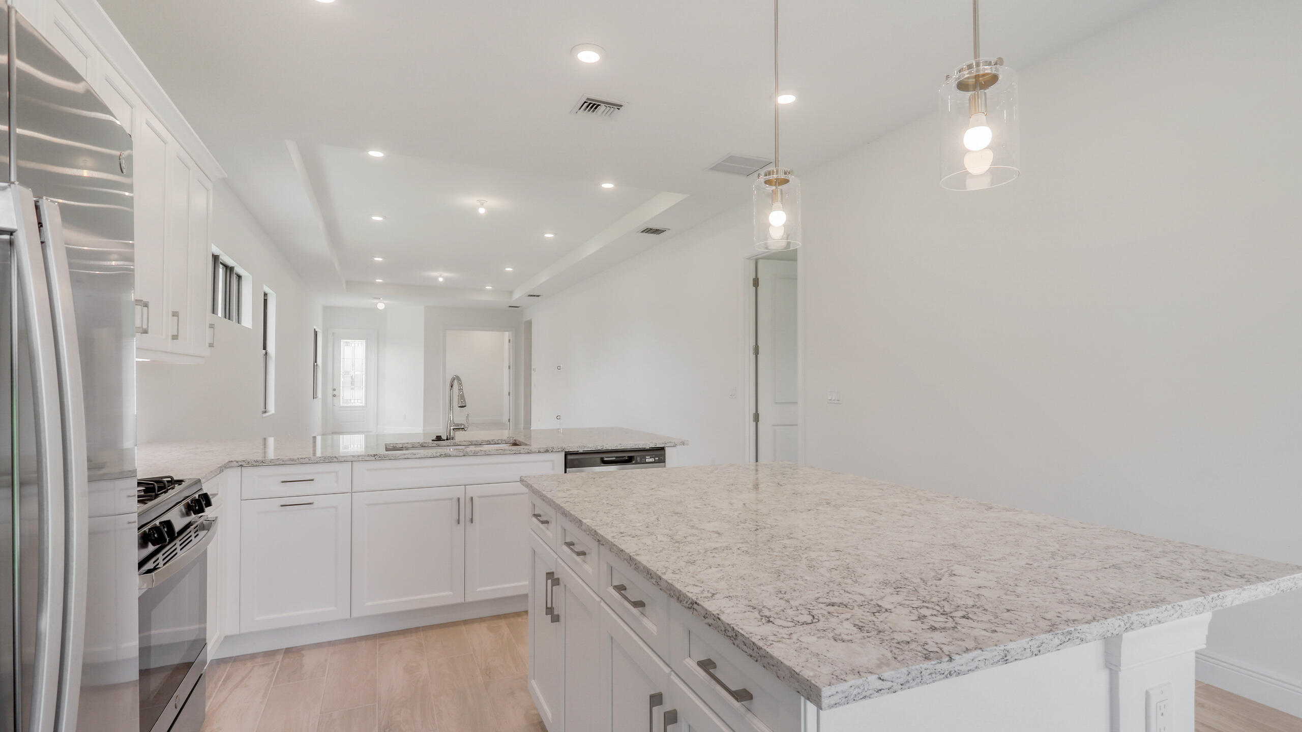 15850 Alys Terrace Westlake, FL 33470 - Photo 3 of 26 a large kitchen with granite countertop a sink white cabinets and stainless steel appliances