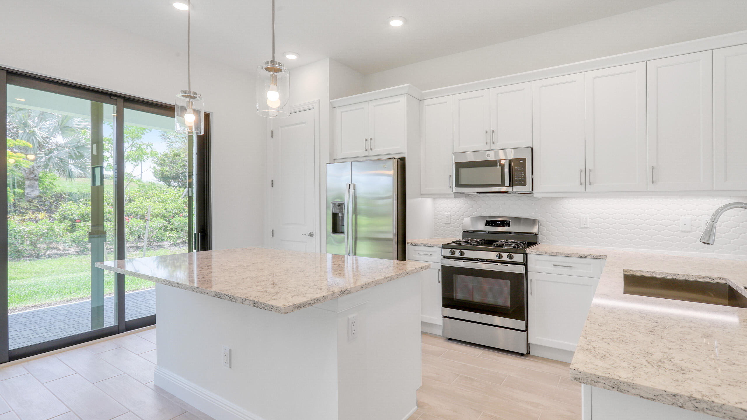 15850 Alys Terrace Westlake, FL 33470 - Photo 4 of 26 a kitchen with stainless steel appliances granite countertop a stove a sink and a refrigerator with white cabinets