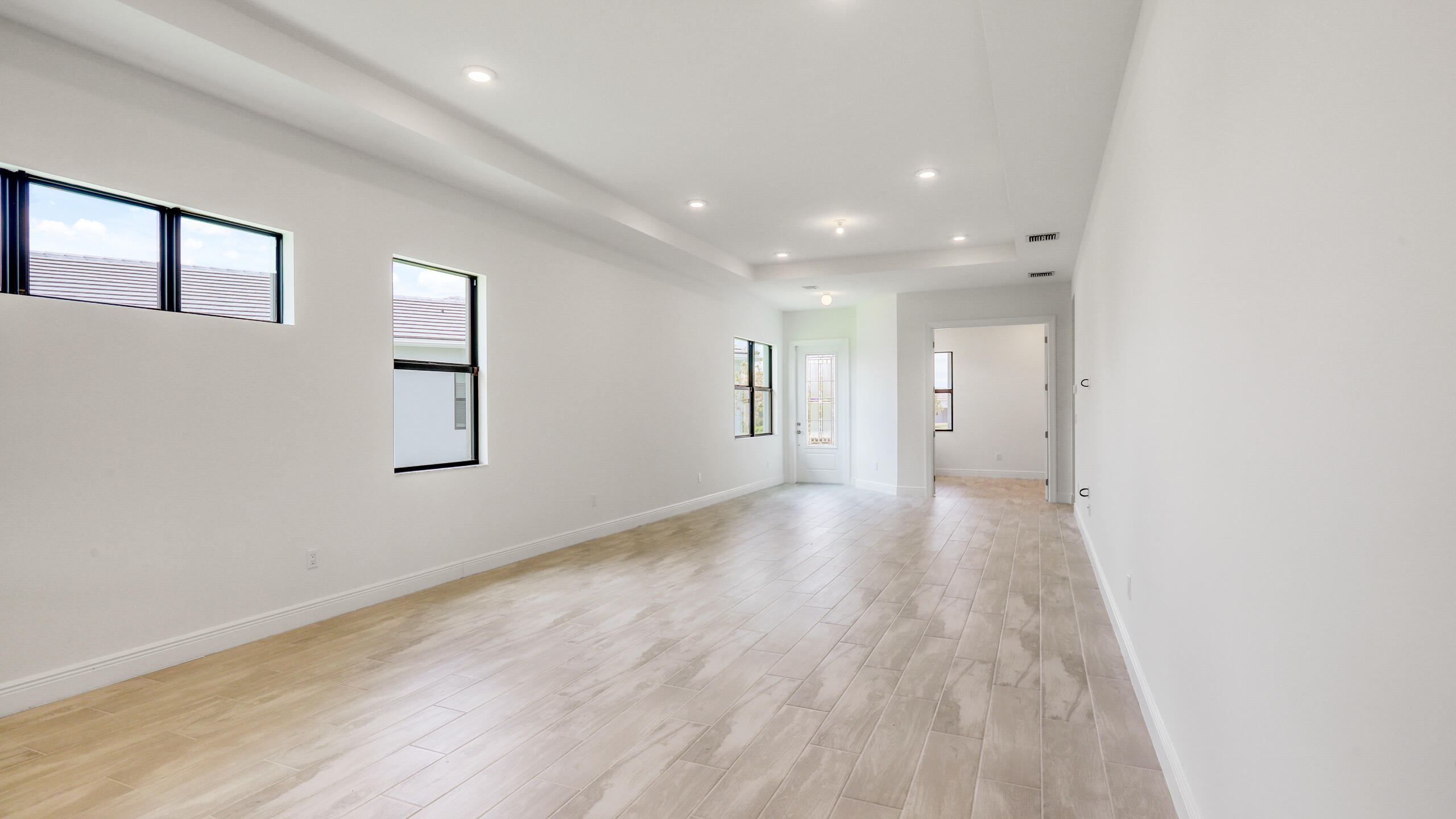 15850 Alys Terrace Westlake, FL 33470 - Photo 9 of 26 a view of a big room with wooden floor and windows