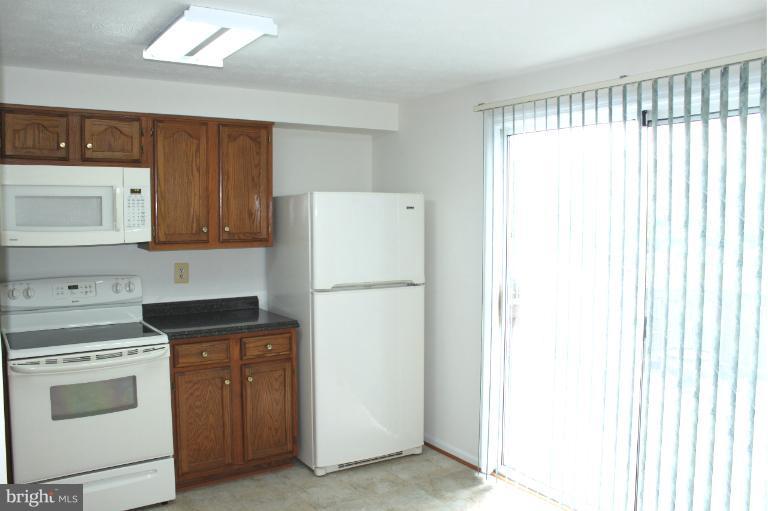 2243 Riding Crop Way Windsor Mill, MD 21244 - Photo 5 of 12 a kitchen with a white stove top oven and sink