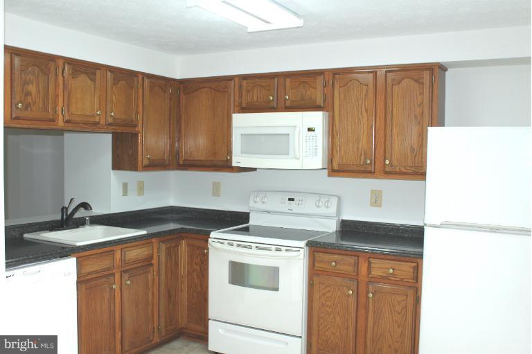 2243 Riding Crop Way Windsor Mill, MD 21244 - Photo 9 of 12 a kitchen with granite countertop a sink stove and cabinets