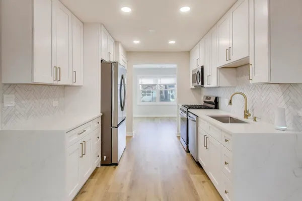 a kitchen with stainless steel appliances sink stove refrigerator and cabinets