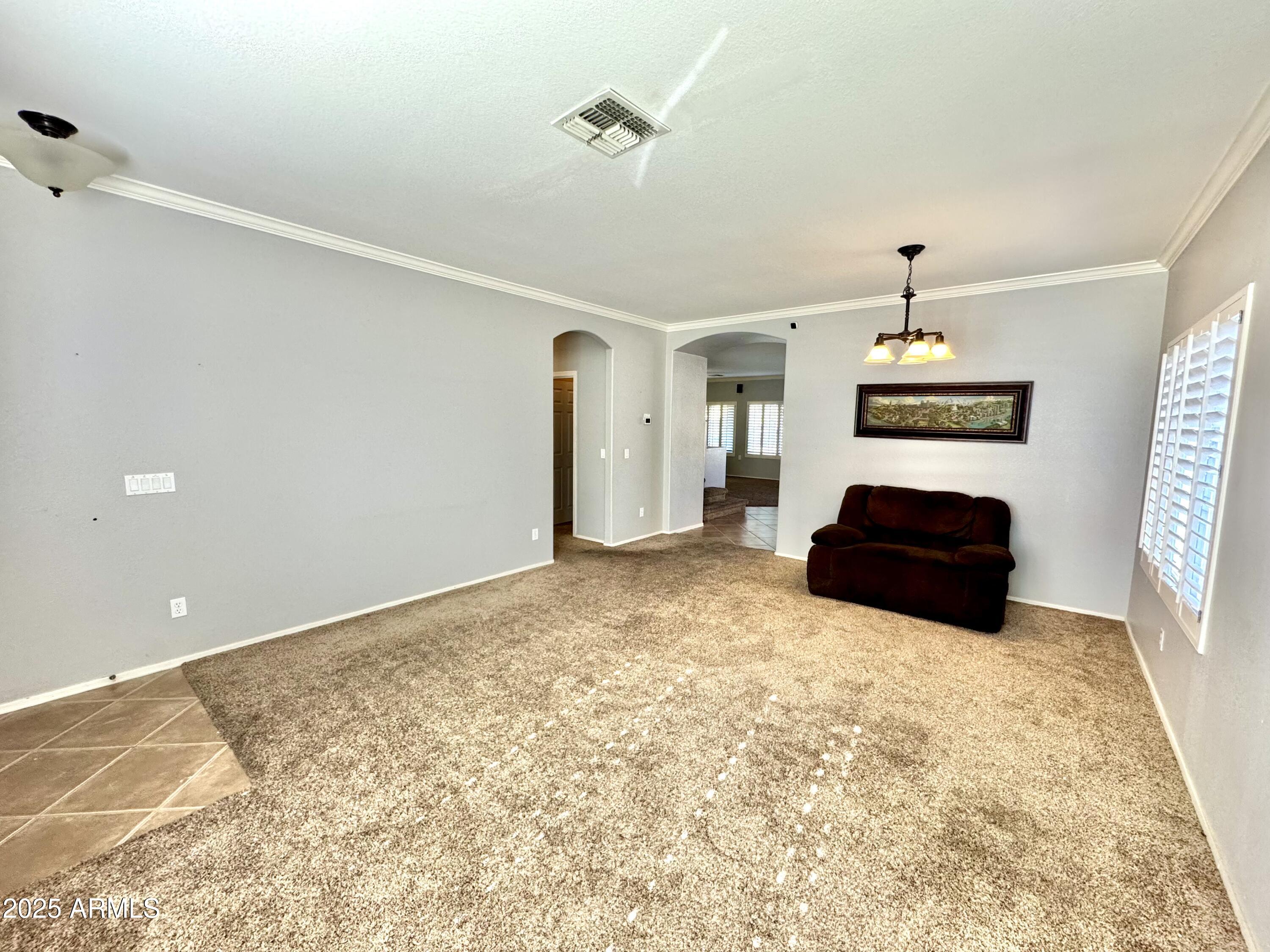 44518 Redrock Road Maricopa, AZ 85139 - Photo 3 of 14 a spacious bedroom with a bed and a chandelier