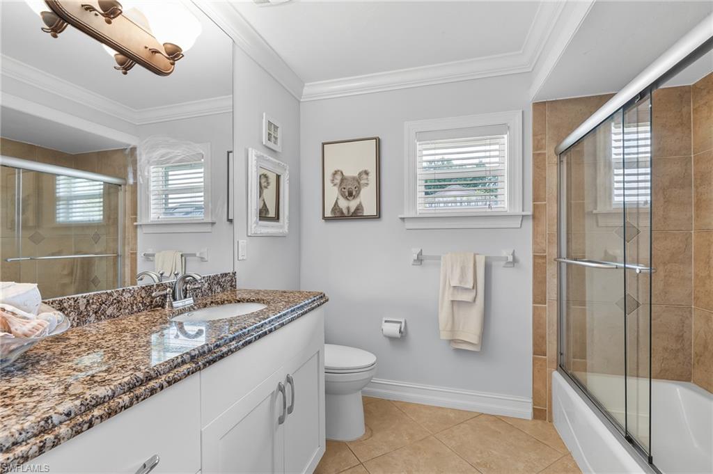1904 Countess Court Naples, FL 34110 - Photo 22 of 33 a bathroom with a granite countertop sink toilet and shower