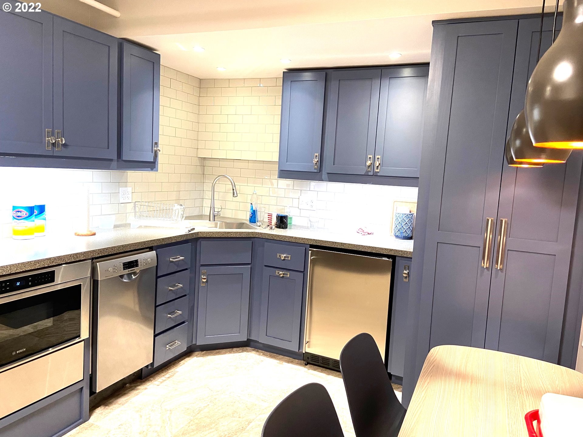 1730 South Harbor Way, Unit 405 Portland, OR 97201 - Photo 28 of 32 a kitchen with stainless steel appliances granite countertop wooden cabinets a sink a stove a dining table and chairs