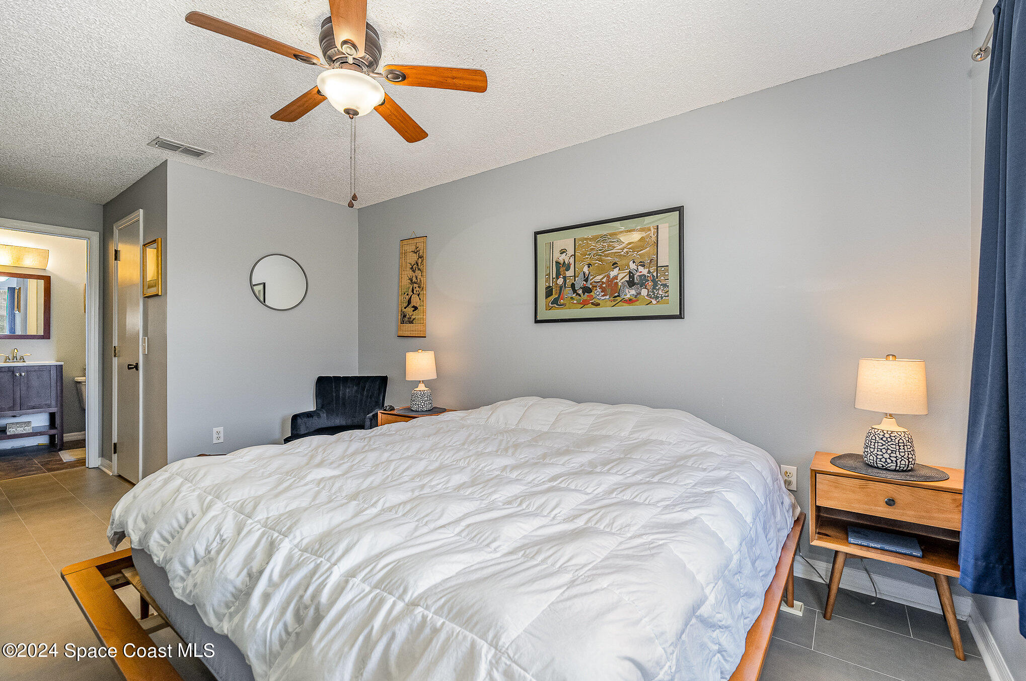 280 Spring Drive, Unit 4 Merritt Island, FL 32953 - Photo 18 of 32 a bedroom with a bed and a chandelier