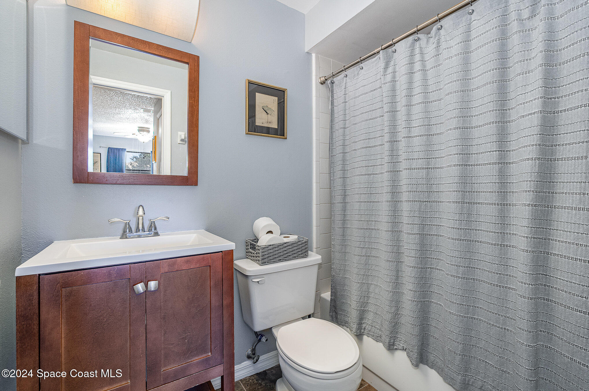 280 Spring Drive, Unit 4 Merritt Island, FL 32953 - Photo 19 of 32 a bathroom with a toilet a sink and mirror