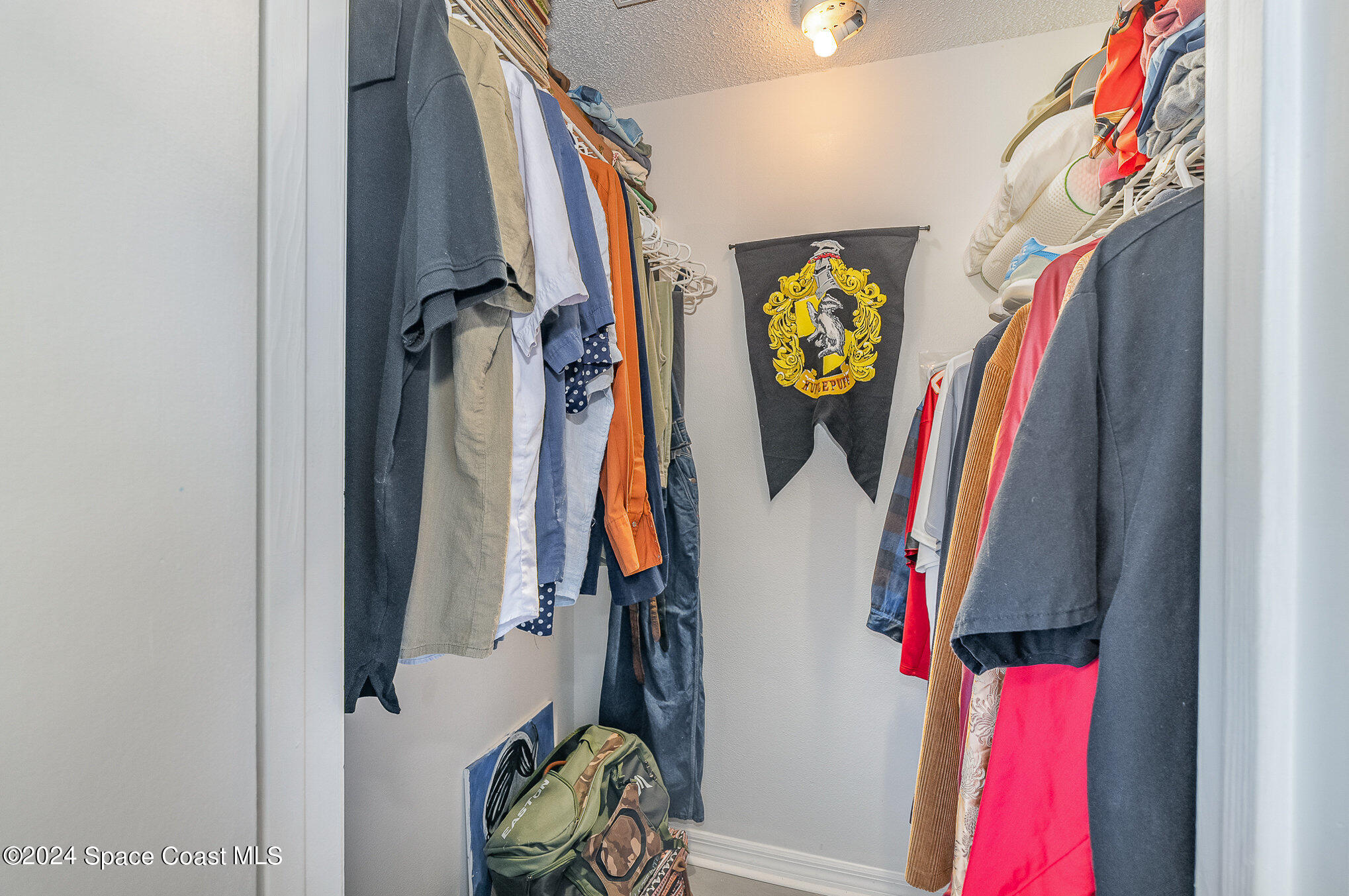 280 Spring Drive, Unit 4 Merritt Island, FL 32953 - Photo 20 of 32 a view of walk in closet with clothes and shoes