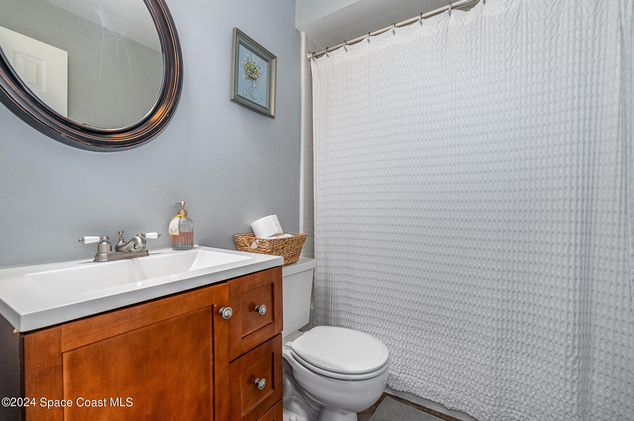280 Spring Drive, Unit 4 Merritt Island, FL 32953 - Photo 23 of 32 a bathroom with a toilet a sink and a mirror