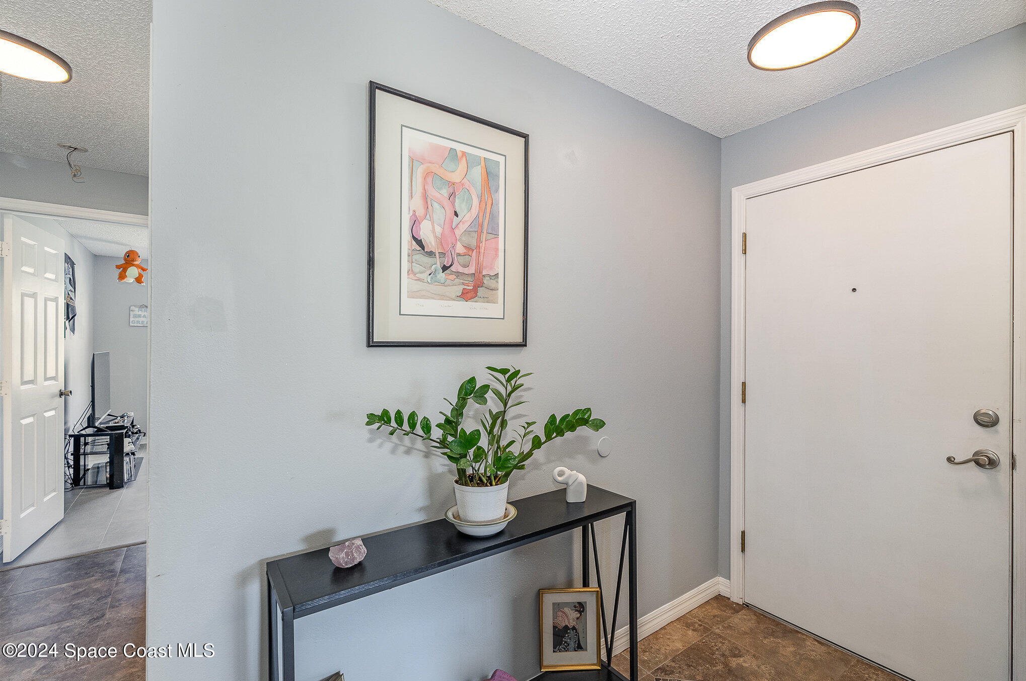 280 Spring Drive, Unit 4 Merritt Island, FL 32953 - Photo 4 of 32 a view of a hallway with wooden floor and a potted plant