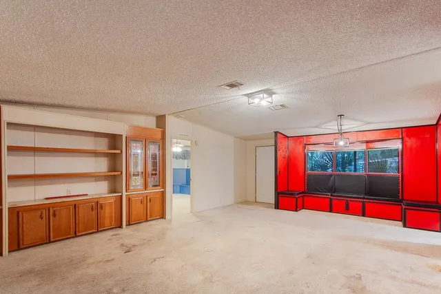 an empty room with red walls and windows