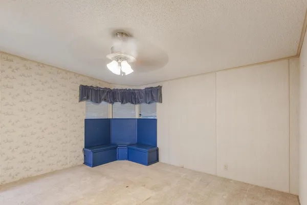 an empty room with wooden floor and chandelier fan