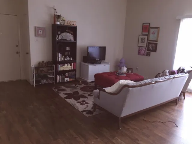 a view of an empty room with wooden floor