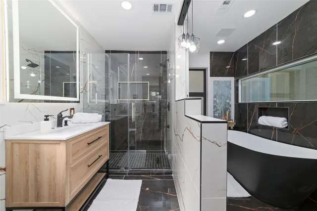 a bathroom with a sink a toilet a mirror and shower