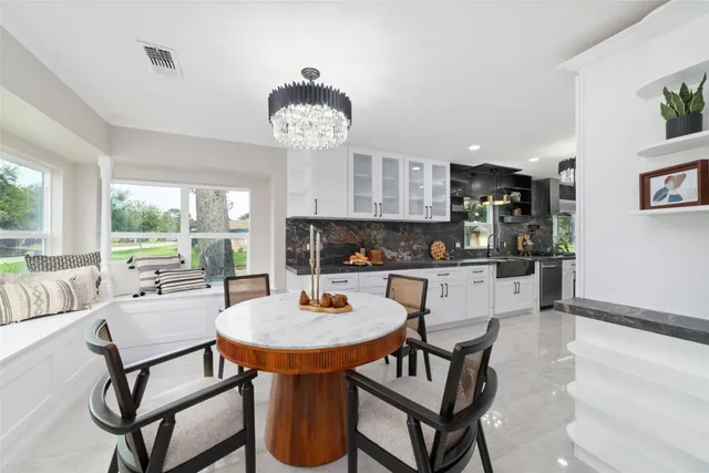 a view of a dining room with furniture a chandelier and wooden floor