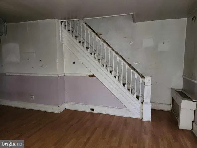 a kitchen with stainless steel appliances granite countertop a refrigerator a sink dishwasher a stove and a oven with wooden floor