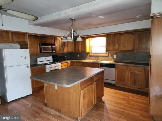 a kitchen with stainless steel appliances granite countertop a sink a refrigerator and a stove