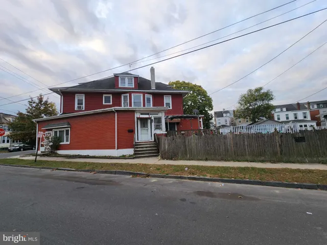 a view of a house with a yard and large tree