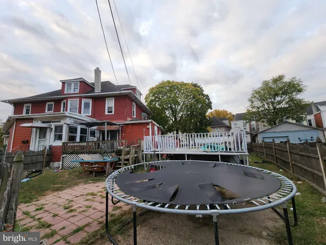 a roof deck with a barbeque and plants