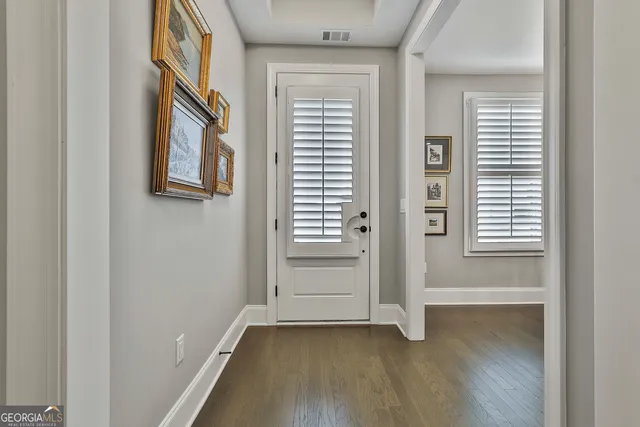a dining room with furniture a chandelier and wooden floor