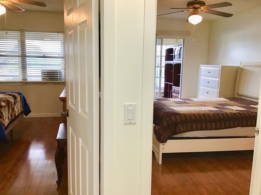 2038 Exeter C, Unit 2038 Boca Raton, FL 33434 - Photo 12 of 37 a bedroom with a bed and a chandelier