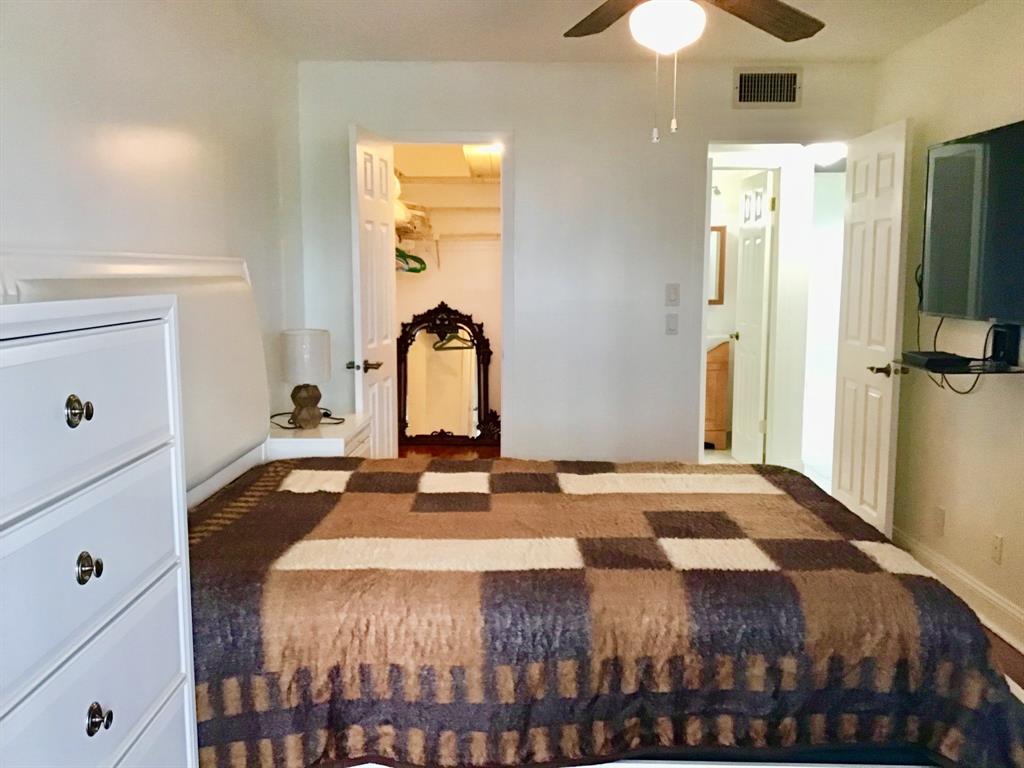 2038 Exeter C, Unit 2038 Boca Raton, FL 33434 - Photo 17 of 37 a bedroom with a bed and a chandelier