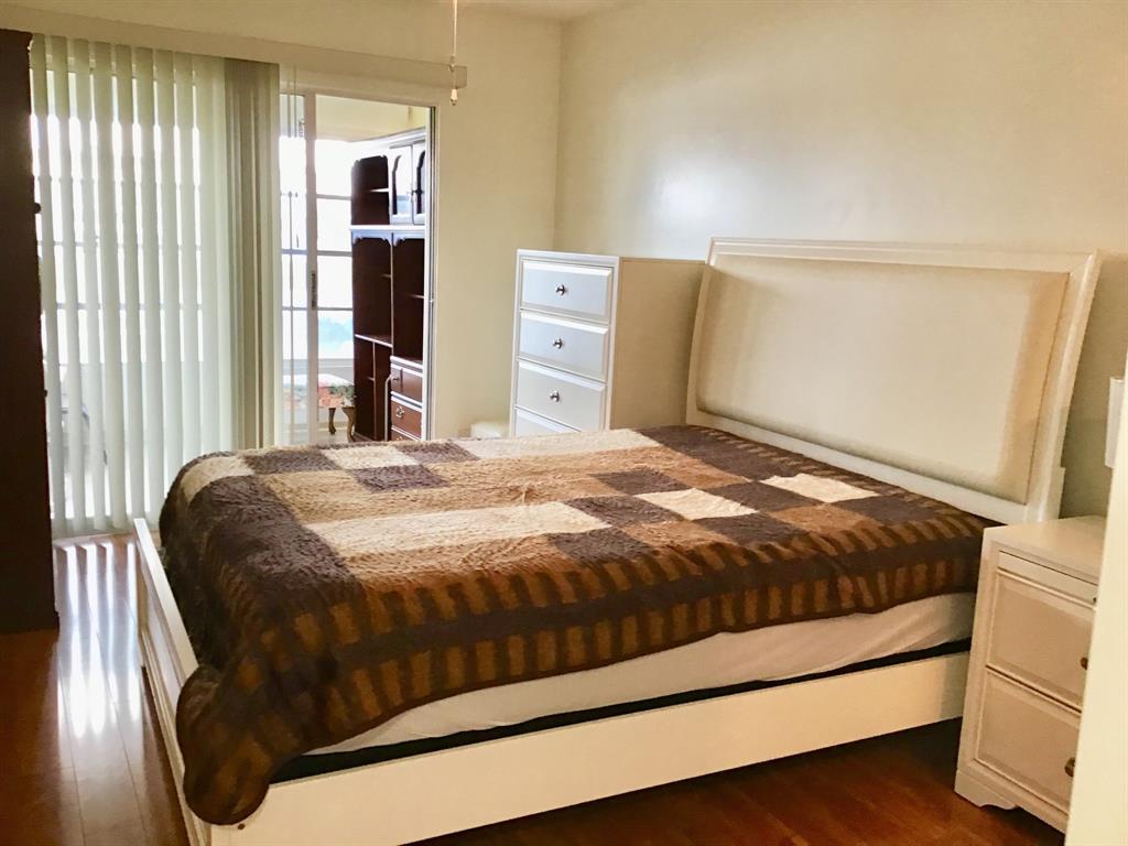 2038 Exeter C, Unit 2038 Boca Raton, FL 33434 - Photo 21 of 37 a bed sitting in a bedroom next to a window