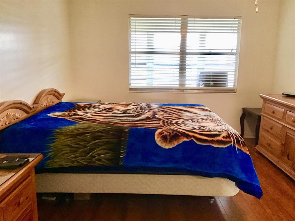 2038 Exeter C, Unit 2038 Boca Raton, FL 33434 - Photo 23 of 37 a bedroom with a bed and a wooden floor