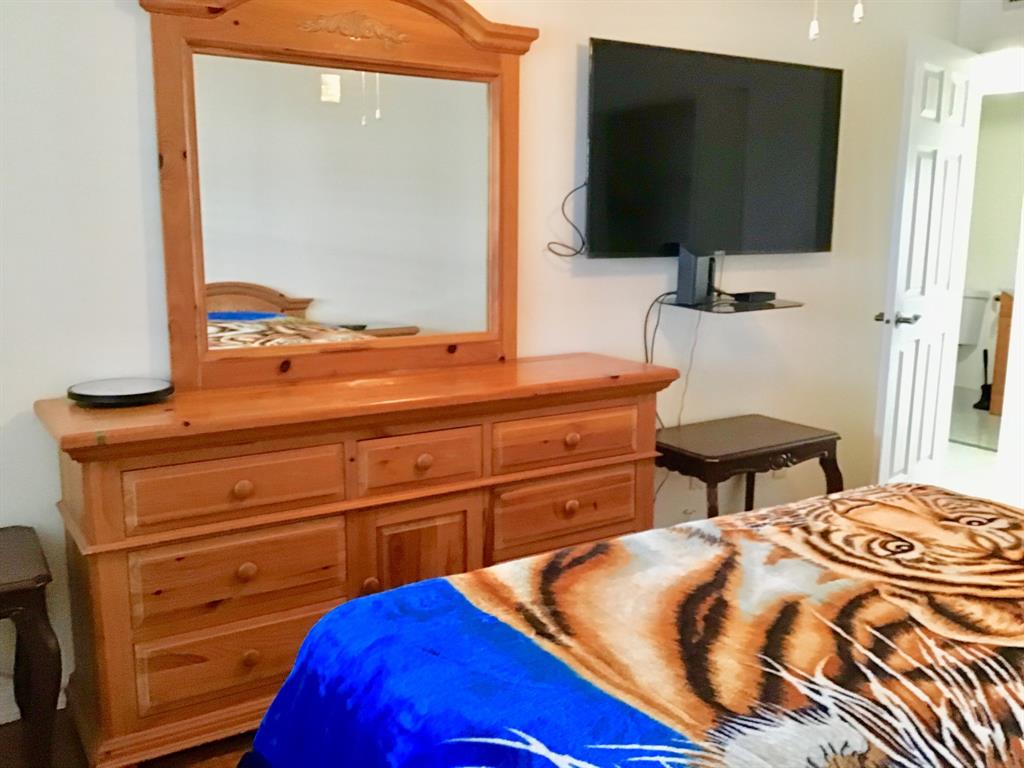 2038 Exeter C, Unit 2038 Boca Raton, FL 33434 - Photo 25 of 37 a bedroom with a bed and a flat screen tv