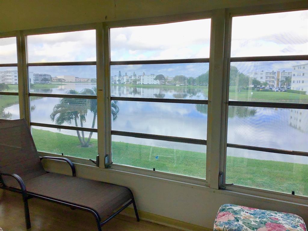 2038 Exeter C, Unit 2038 Boca Raton, FL 33434 - Photo 27 of 37 a living room with a large window and a table