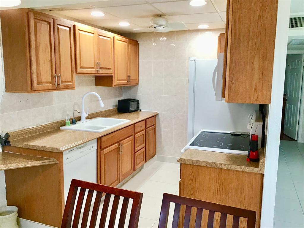 2038 Exeter C, Unit 2038 Boca Raton, FL 33434 - Photo 3 of 37 a utility room with cabinets washer and dryer