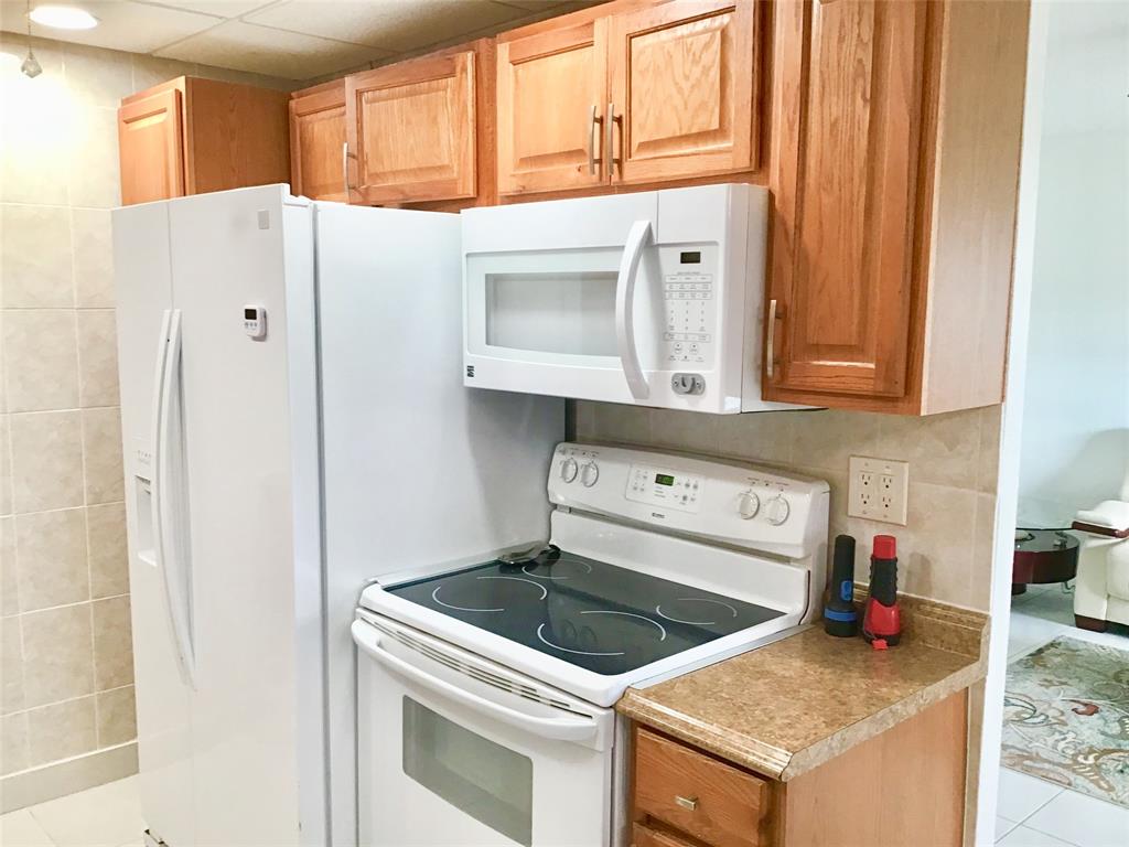 2038 Exeter C, Unit 2038 Boca Raton, FL 33434 - Photo 5 of 37 a kitchen with stainless steel appliances granite countertop a stove and a refrigerator with cabinets