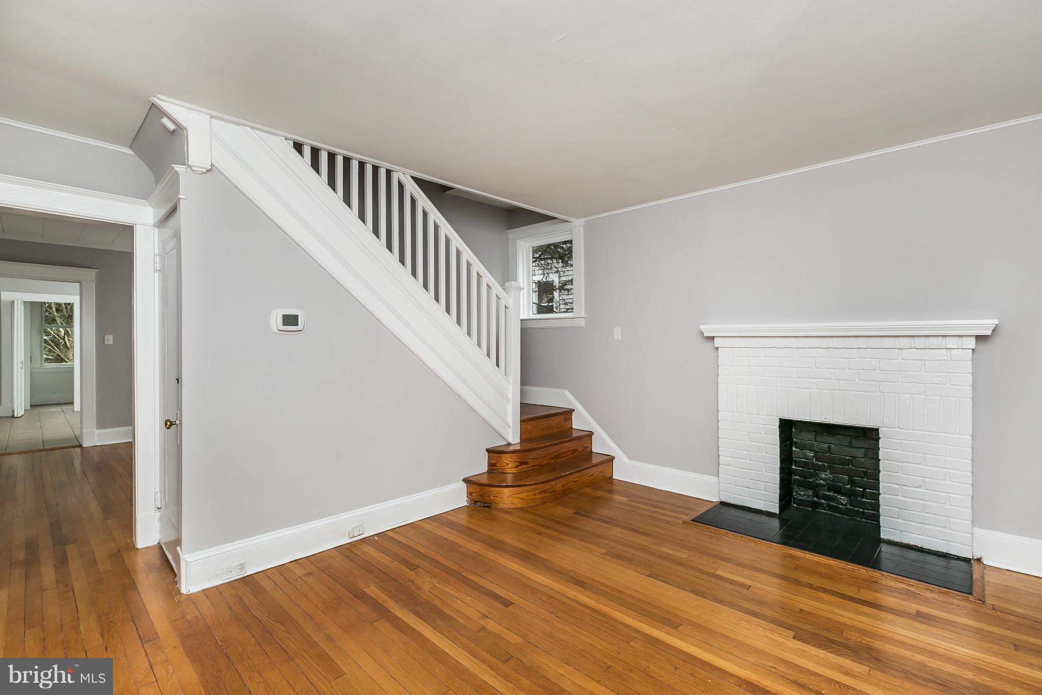 621 Deepdene Road Baltimore, MD 21210 - Photo 6 of 27 a view of an empty room with wooden floor and a fireplace