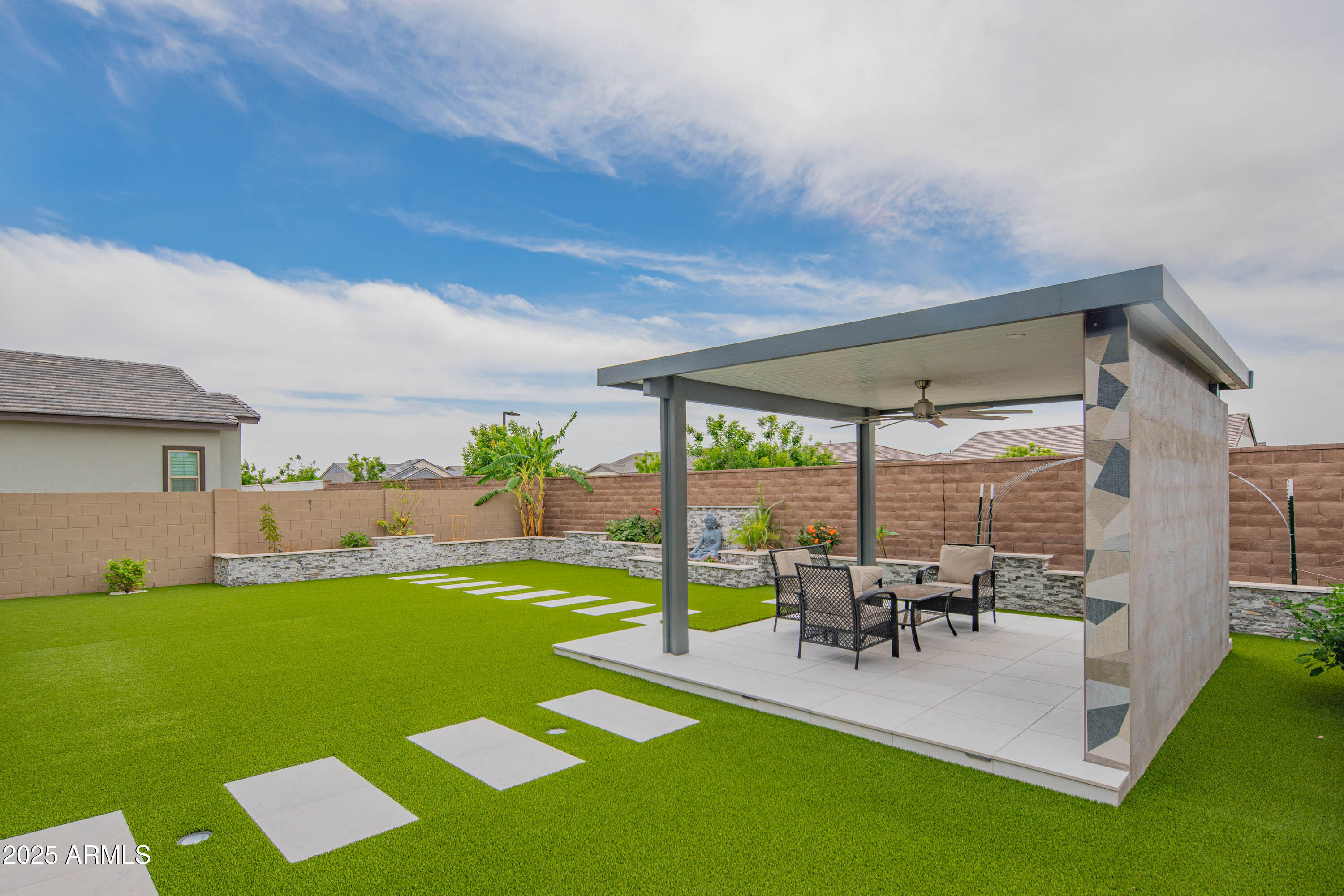 5232 South Cobblestone Street Gilbert, AZ 85298 - Photo 55 of 71 a view of a patio with table and chairs potted plants and floor to ceiling window