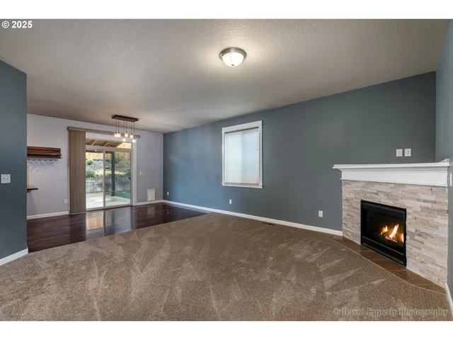 a view of an empty room with window and fire place