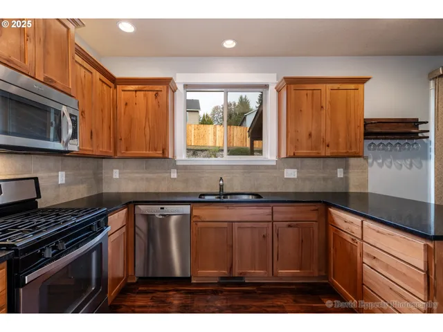 a kitchen with stainless steel appliances granite countertop a sink stove and microwave