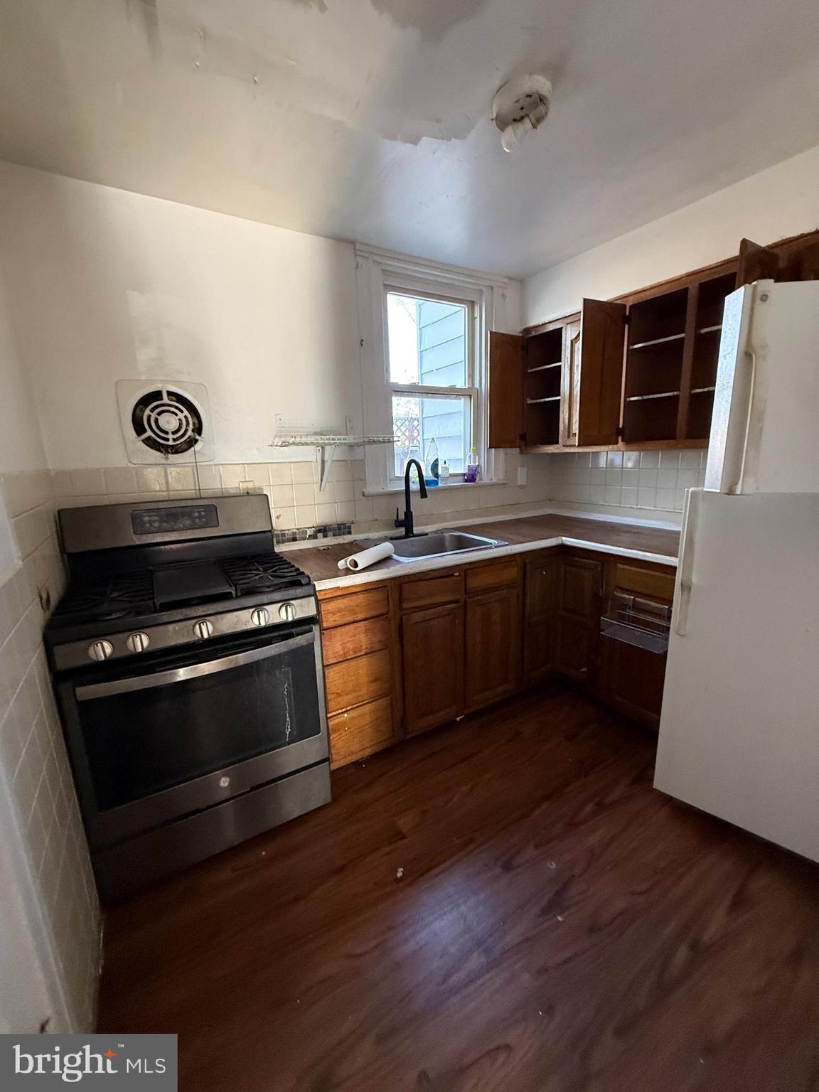 411 Timberlake Road Upper Darby, PA 19082 - Photo 2 of 15 a kitchen with wooden cabinets and a stove top oven