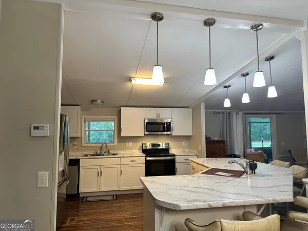 a kitchen with stainless steel appliances granite countertop a stove a sink and a refrigerator