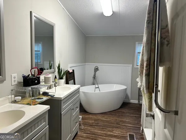 a spacious bathroom with a double vanity sink a mirror and a bathtub