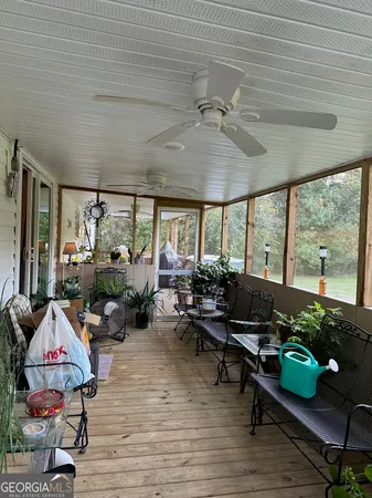 a living room with patio furniture and a floor to ceiling window