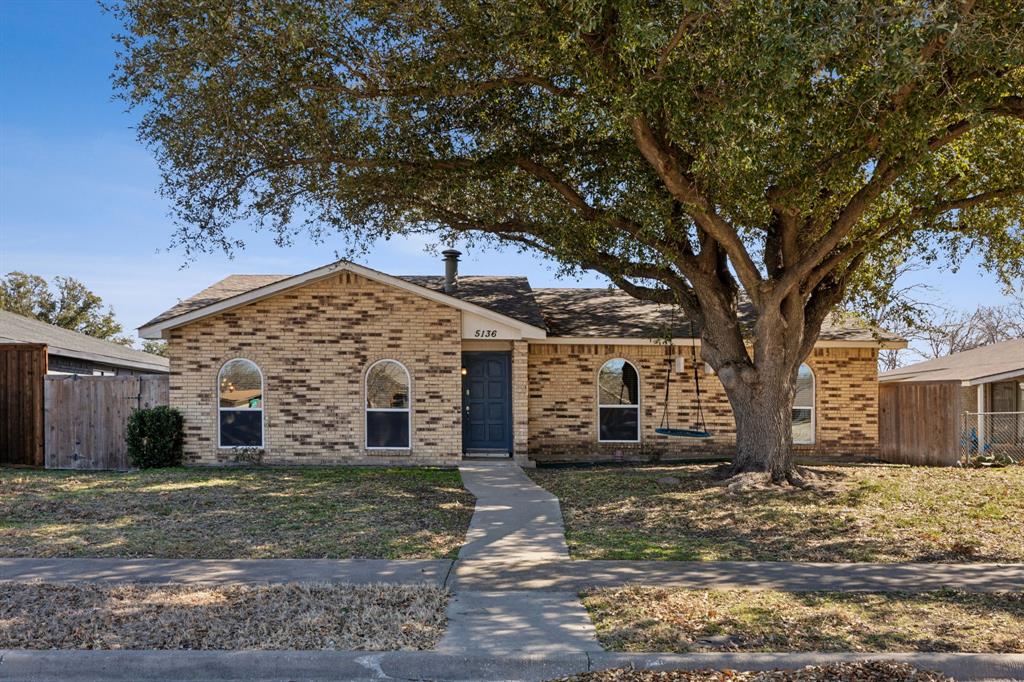 front view of a house with a tree