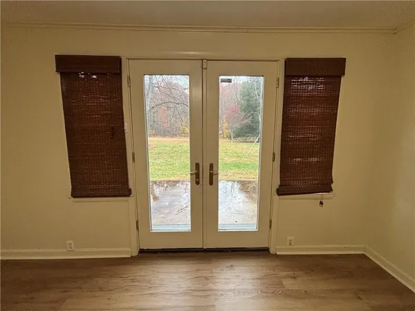 an empty room with wooden floor and windows