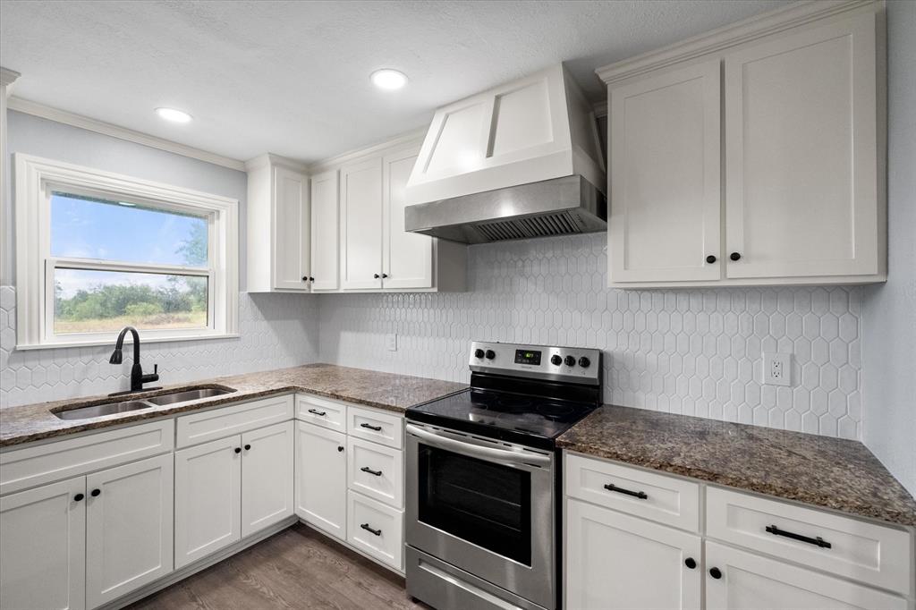 1009 North Spikes Road Corsicana, TX 75110 - Photo 5 of 31 a kitchen with stainless steel appliances granite countertop white cabinets granite counter tops and a wooden floors